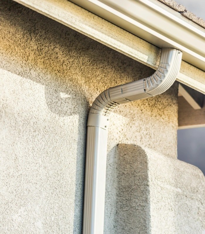 Gutter Cleaning Service in Oviedo - FL technician clearing wet leaves from a front roof gutter